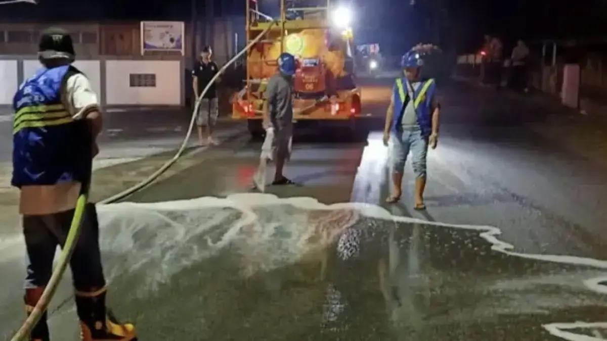 Petugas BPK Swasta Sambas turun membersihkan tumpahan minyak di Jalan A Yani kawasan Siapat, Desa Lorong, Kecamatan Sambas, Senin (11/5) malam.