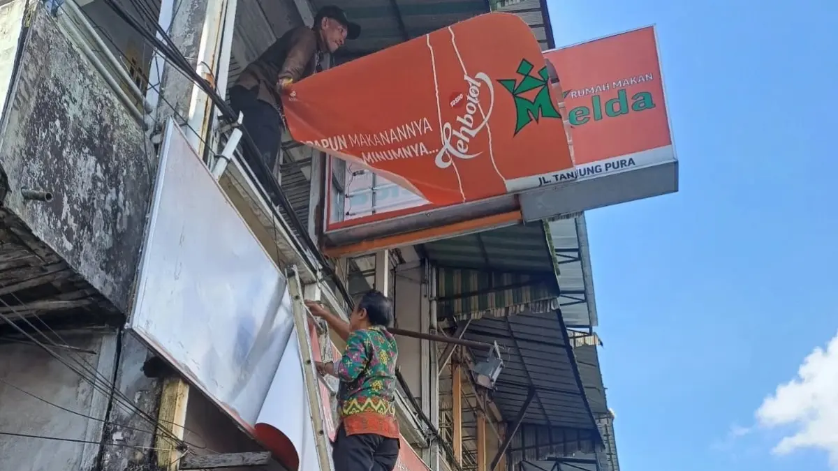 Petugas melakukan pembongkaran reklame yang belum melunasi kewajiban pajaknya. (ISTIMEWA)