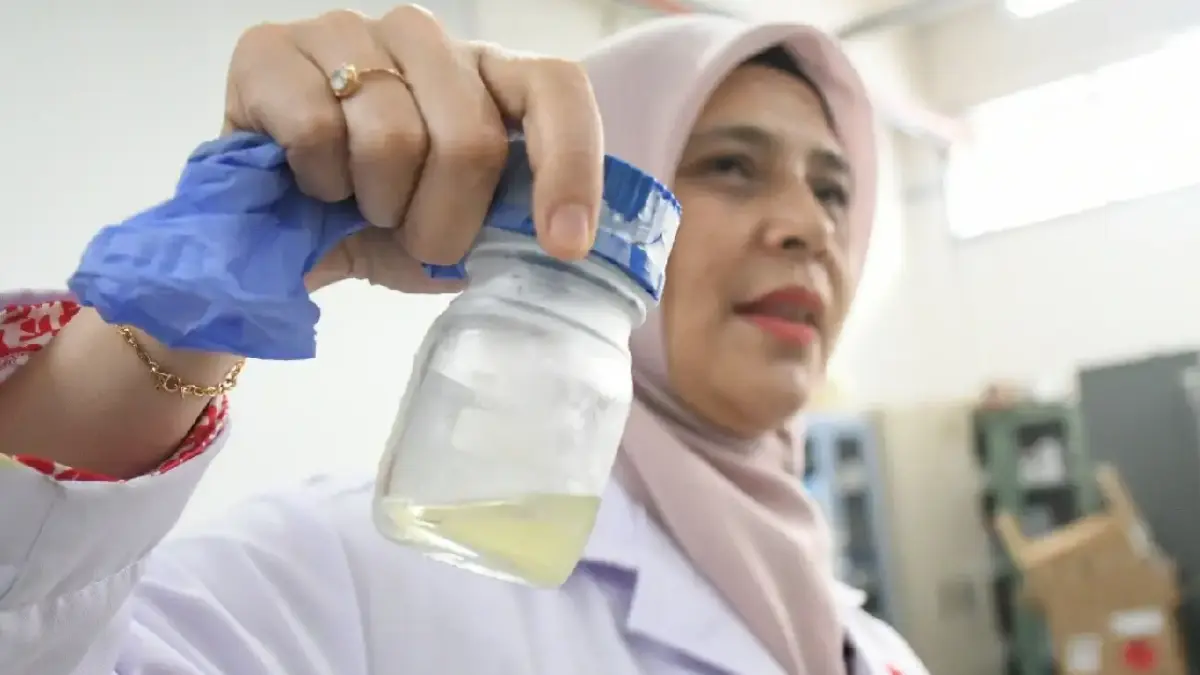 Periset BRIN menunjukkan proses pengolahan limbah tandan kosong kelapa sawit menjadi minyak biomassa melalui teknologi pirolisis. (Dok.BRIN)