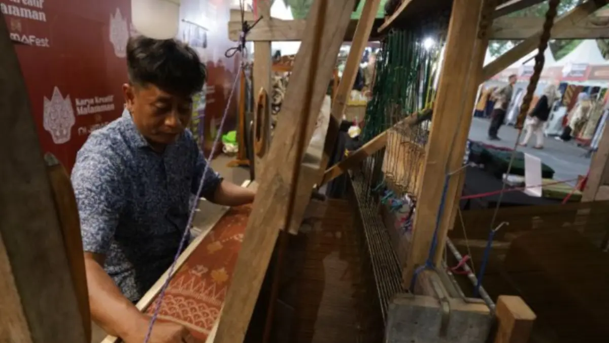 Seorang perajin menenun kain ikat khas Kediri saat kegiatan Karya Kreatif Mataraman X Digimafest 2026 di Kabupaten Kediri, Jawa Timur, Jumat (26/6).&nbsp; (ANTARA FOTO/Prasetia Fauzani/nym).