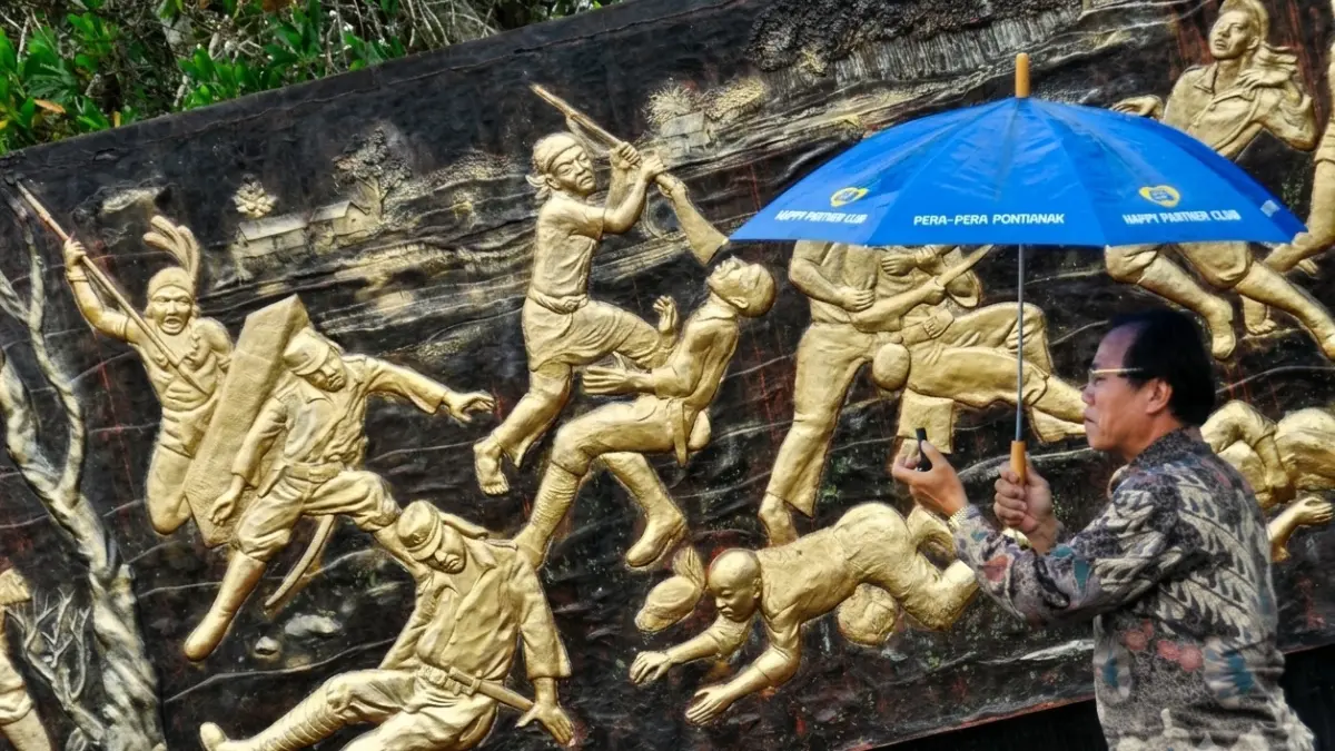 Seorang pria mengabadikan relief di Monumen Makam Juang Mandor, Kabupaten Landak.  (DOK. ANTARA)