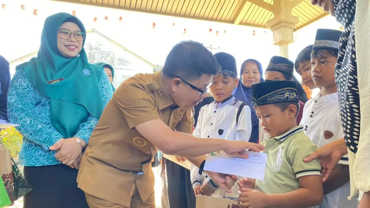 Bupati Sambas Satono menyerahkan hadiah berupa sarung dan uang kepada peserta khitanan massal di SD Negeri 1 Sekura, Senin (29/6). (ISTIMEWA)