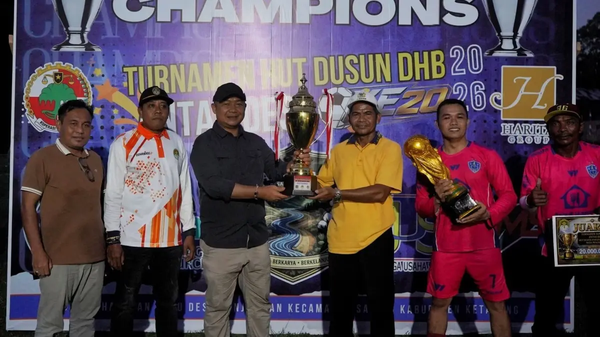 JUARA : Bupati Ketapang, Alexander Wilyo, menyerahkan piala kepada PSM 99 FC yang berhasil menjuarai turnamen sepakbola di Desa Penjawaan, Sandai, beberapa waktu lalu.(IST)