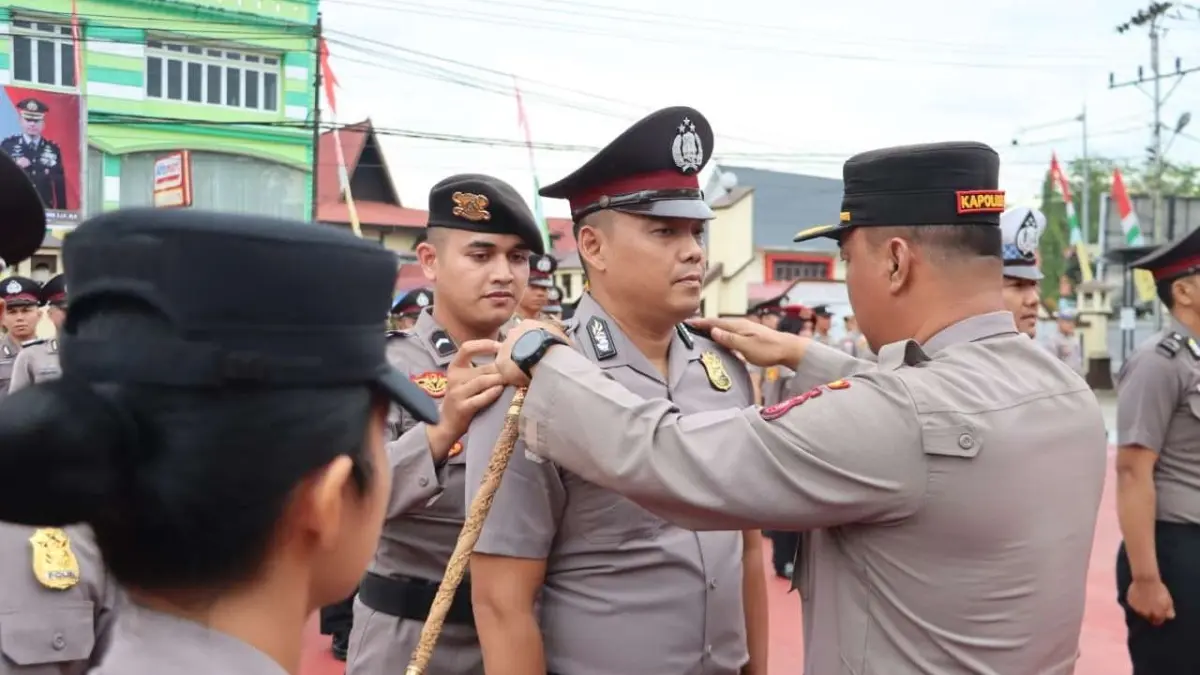 Kapolres Sanggau AKBP Sudarsono membubuhkan tanda kenaikan pangkat kepada sejumlah personel di halaman Mapolres Sanggau, Selasa (30/6). Sebanyak 50 personel menerima kenaikan pangkat sebagai bentuk penghargaan atas dedikasi dan pengabdian mereka. (ISTIMEWA)