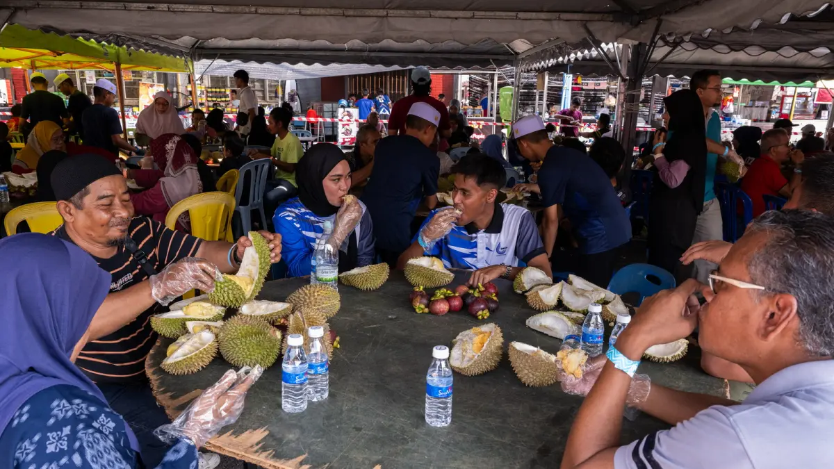 This photo taken on June 28, 2026 shows visitors enjoying fresh durian during a durian festival in Karak, in Malaysia