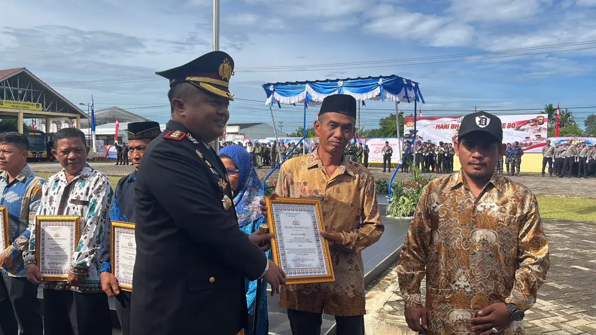 Kapolres Sambas AKBP Wahyu Jati menyerahkan penghargaan kepada masyarakat dan personel yang dinilai berkontribusi mendukung tugas kepolisian, usai Upacara Hari Bhayangkara ke-80 di Mapolres Sambas, Rabu (1/7). 