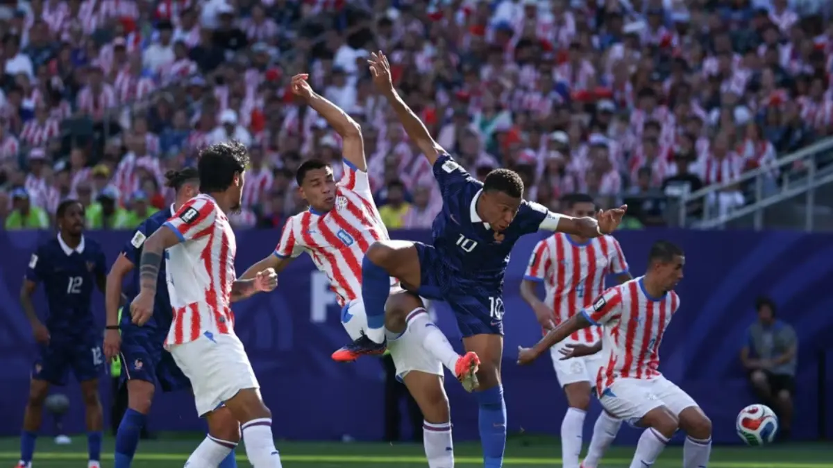 
PERTANDINGAN KERAS: Kylian Mbappe berusaha melepaskan diri dari kawalan ketat pemain Paraguay pada babak 16 besar Piala Dunia FIFA 2026 di Philadelphia. Gol penalti Mbappe menjadi penentu kemenangan 1-0 Prancis.  (FOTO: FIFA)
