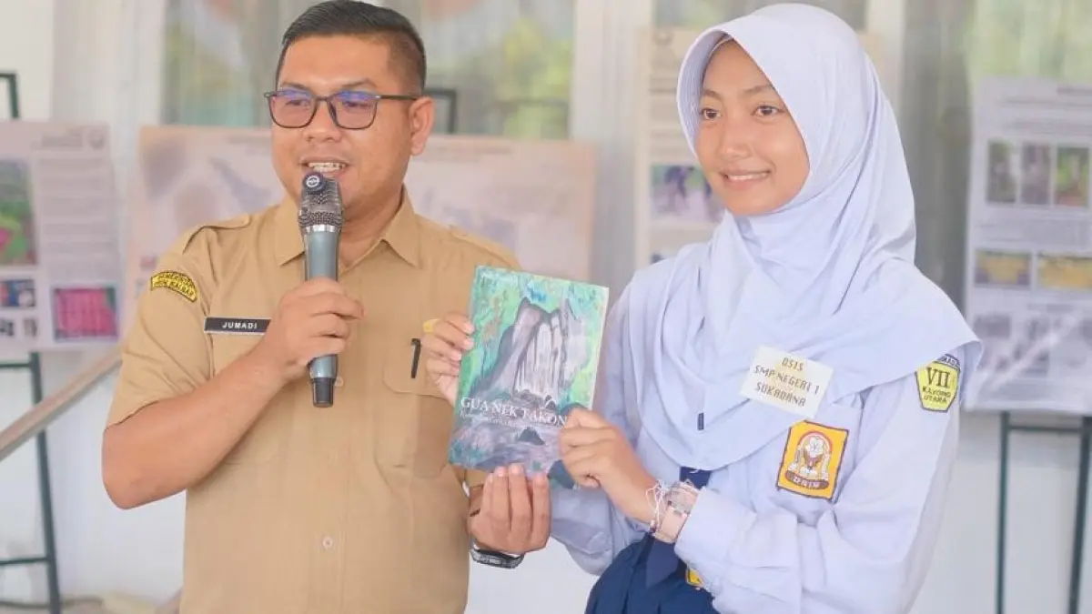 Kepala Dinas Pendidikan Jumadi bersama siswi SMPN 1 Sukadana mengenal buku cerita rakyat Kayong Utara beberapa waktu lalu..(ISTIMEWA)