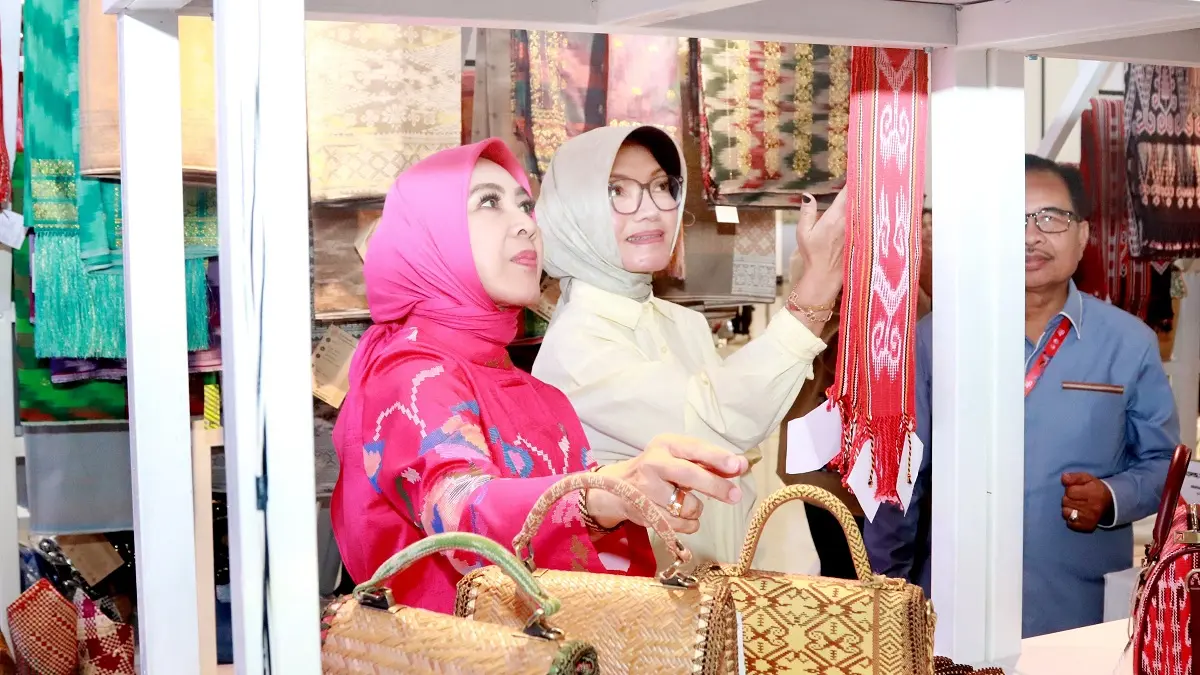Ketua Harian Dekranas, Ny. Tri Tito Karnavian, didampingi Ketua Dekranasda Kota Pontianak Yanieta Arbiastutie, mengamati produk kerajinan di stan Dekranasda Kalimantan Barat pada rangkaian HUT ke-46 Dekranas di Makassar, Jumat (10/7). (ISTIMEWA)