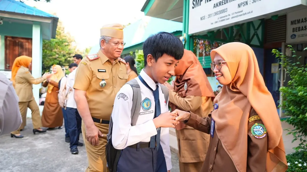 Sekda Kalbar, Harisson mengantar putra bungsunya, M. Istiqlal Azziqra Gibrani ke SMP Negeri 3 Pontianak pada hari pertama masuk sekolah Tahun Ajaran 2026/2027, Senin (13/7). (ISTIMEWA)