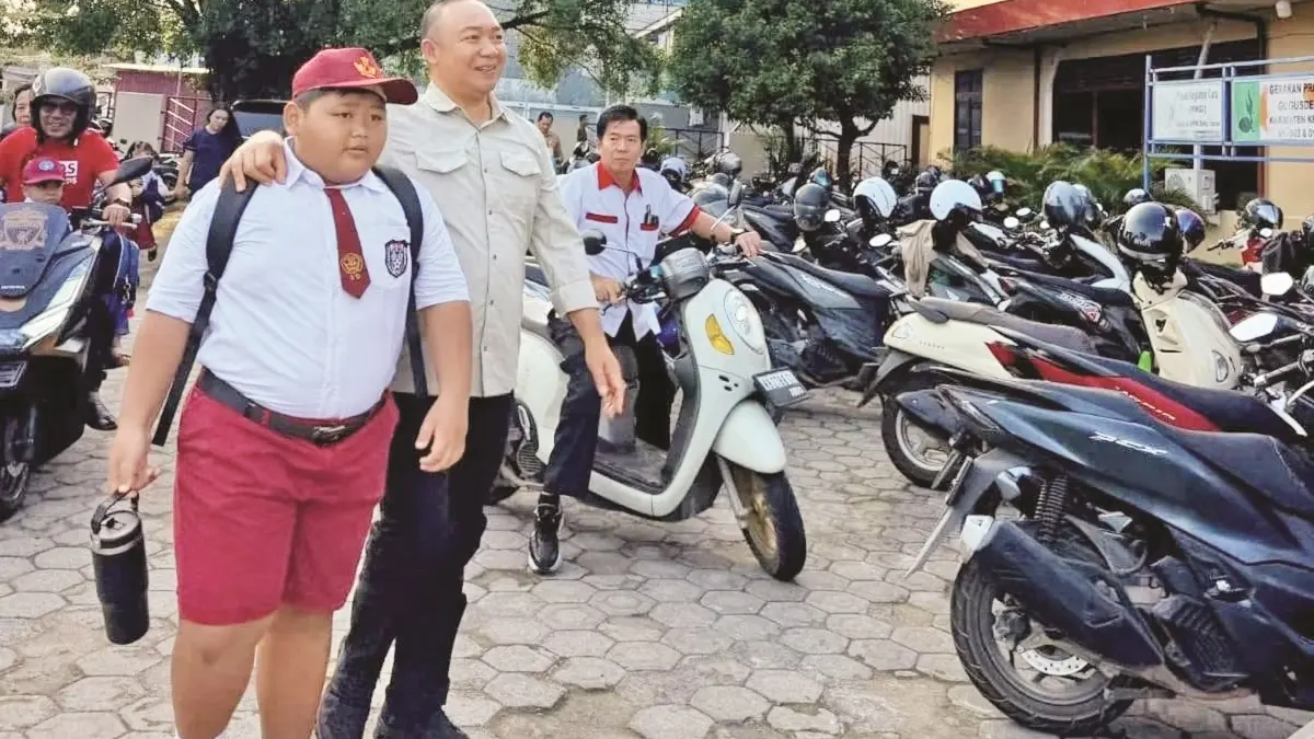 Bupati Ketapang, Alexander Wilyo, mengantarkan anak ke sekolah di Kota Ketapang, Senin (13/7). (ISTIMEWA)