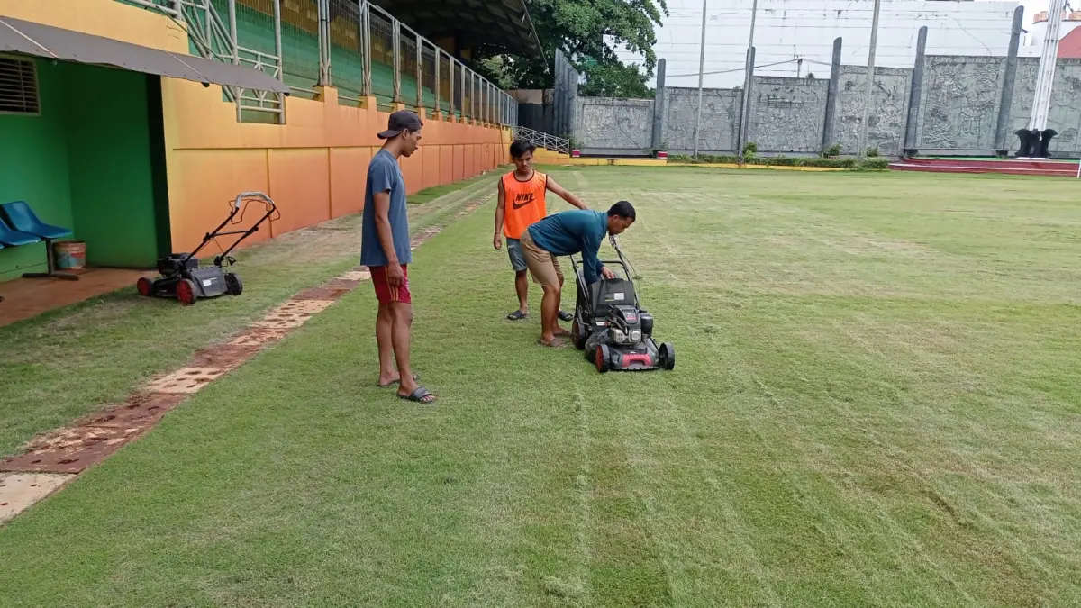 Misno dan rekan tengah melakukan perawatan rumput lapangan PSP. (MIRZA AHMAD MUIN/PONTIANAKPOST)