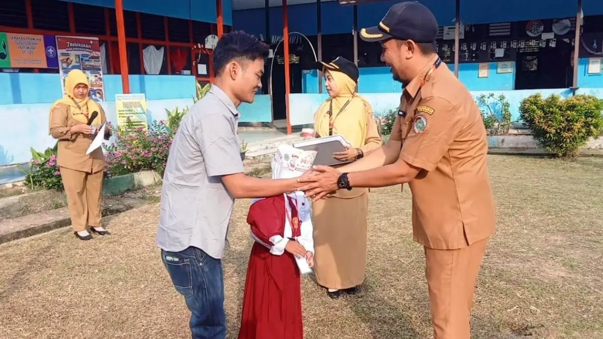 Sambut: Kepala SDN 09 Mempawah Hilir, Hidaya, saat menyambut siswa baru pada hari pertama masuk sekolah