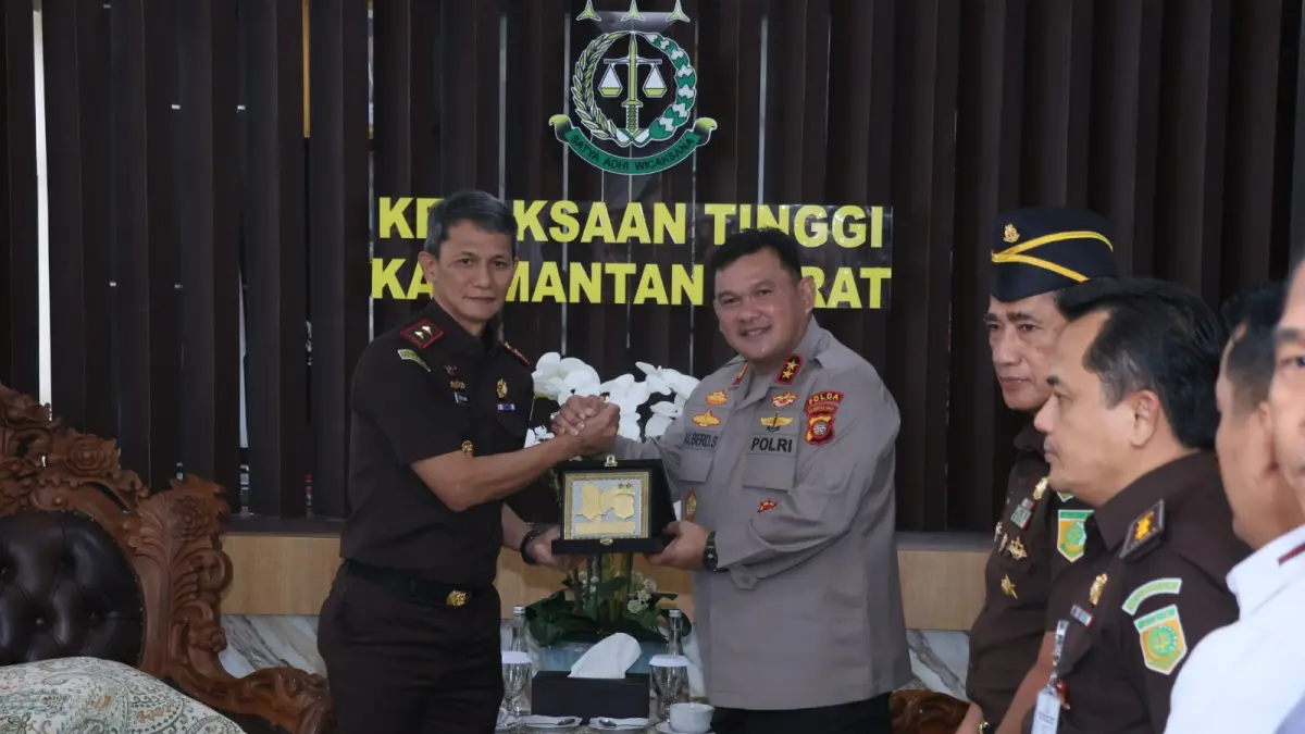 Kapolda Kalbar Irjen Pol Alberd Teddy Benhard Sianipar menyerahkan cenderamata kepada Kajati Kalbar Emilwan Ridwan sebagai simbol penguatan sinergi penegakan hukum saat silaturahmi di Kantor Kejati Kalbar, Pontianak, Selasa (14/7). (ISTIMEWA)