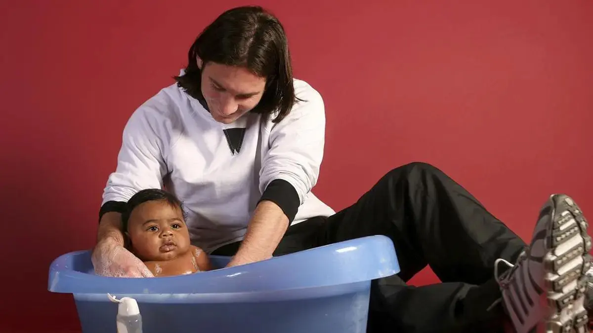 Lionel Messi saat memandikan bayi Lamine Yamal pada 2007. (JOAN MONFORT/UNICEF/AP)