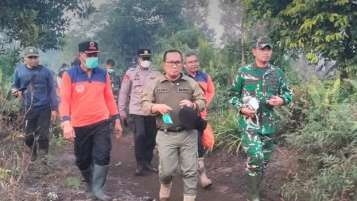 Kapolres Kubu Raya AKBP Kadek Ary Mahardika mendampingi Bupati Kubu Raya Sujiwo meninjau lahan gambut yang terbakat di Kecamatan Sungai Raya. (ANTARA/Rendra Oxtora)