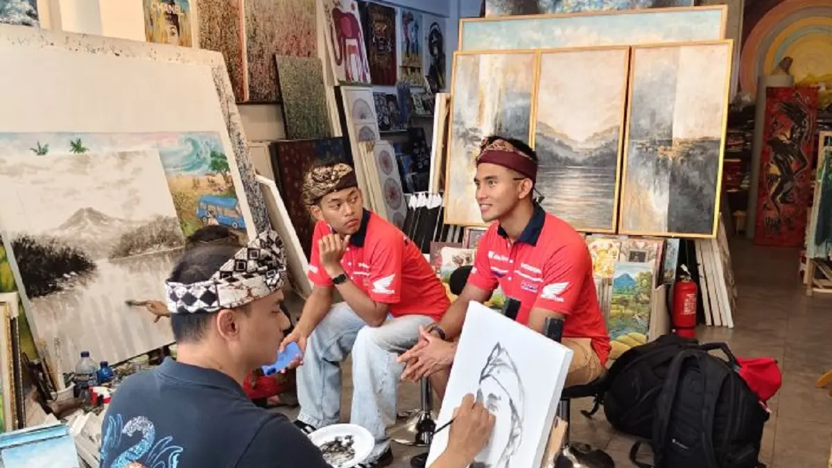 Pembalap Indonesia Vega Ega Pratama (kiri) dan Mario Aji saat mencoba sketsa wajah di kawasan wisata Bali Collection The Nusa Dua, Kabupaten Badung, Bali, Sabtu (18/7). (ANTARA/Dewa Ketut Sudiarta Wiguna)