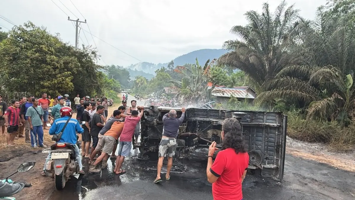 Petugas kepolisian bersama warga mengevakuasi mobil pikap Daihatsu Grand Max yang mengalami kecelakaan di Jalan Trans Kalimantan Kilometer 17, Kecamatan Toba, Kabupaten Sanggau, Selasa (21/7/2026). Kendaraan terguling setelah muncul api dari bak belakang sebelum akhirnya terbakar.