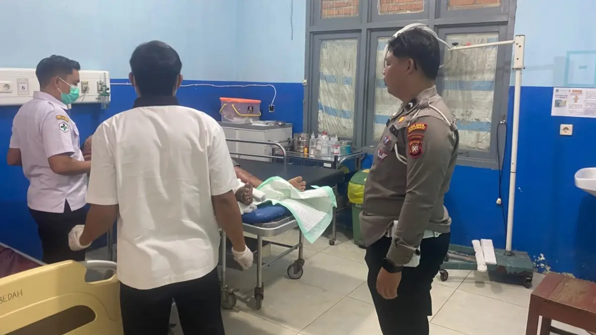 Petugas membantu mengevakuasi korban kecelakaan lalu lintas untuk mendapatkan perawatan medis setelah sepeda motor yang dikendarainya bertabrakan dengan truk box di Jalan Merdeka Selatan, Kabupaten Sekadau, Rabu (22/7). Korban mengalami luka berat berupa patah kaki dan dirujuk ke Rumah Sakit Antonius Pontianak. (Humas Polres Sekadau)