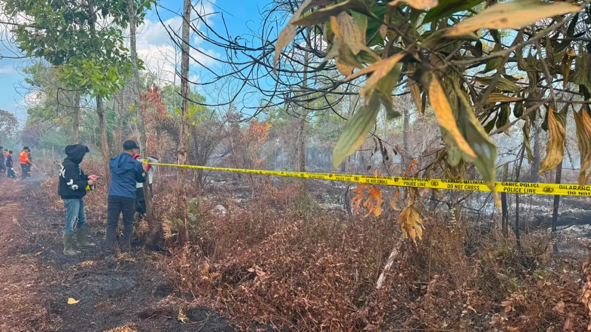 Personel Satreskrim Polres Kubu Raya memasang garis polisi di lahan bekas karhutla seluas sekitar dua hektare di Jalan Parit H. Mukhsin, Desa Parit Baru, Kecamatan Sungai Raya, Selasa (21/7). (ISTIMEWA)