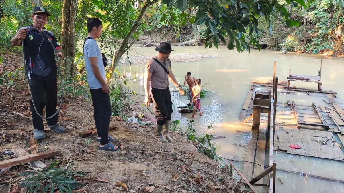 Personel Polsek Meliau bersama aparat desa dan tokoh masyarakat melakukan monitoring di kawasan Sungai Boyan, Kecamatan Meliau, pascaaksi pembakaran peralatan PETI oleh warga, Rabu (22/7). Aktivitas penambangan ilegal di lokasi tersebut dilaporkan telah berhenti. (ISTIMEWA)