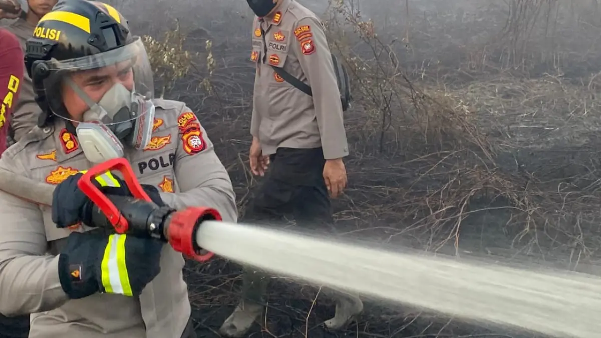 CEGAH MELUAS: Petugas gabungan berjibaku memadamkan kebakaran lahan di depan Perumahan Candramidi, Desa Rasau Jaya III, Kecamatan Rasau Jaya, Kamis (23/7). Sekitar 6 hektare lahan terbakar, sementara proses pendinginan terus dilakukan untuk mencegah bara di lapisan gambut memicu kebakaran susulan.