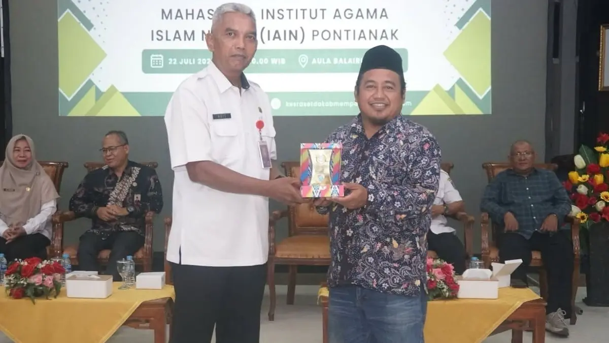 Staf Ahli Bupati Mempawah Bidang Kemasyarakatan dan Sumber Daya Manusia, Agit Sugiarto menyerahkan cinderamata kepada pihak IAIN Pontianak. (ISTIMEWA)