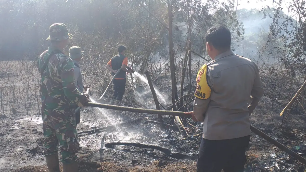 Personel Polsek Muara Pawan bersama TNI, BPBD Kabupaten Ketapang, Manggala Agni, perangkat desa, dan masyarakat memadamkan kebakaran lahan gambut di Desa Tempurukan, Kecamatan Muara Pawan, Kabupaten Ketapang.