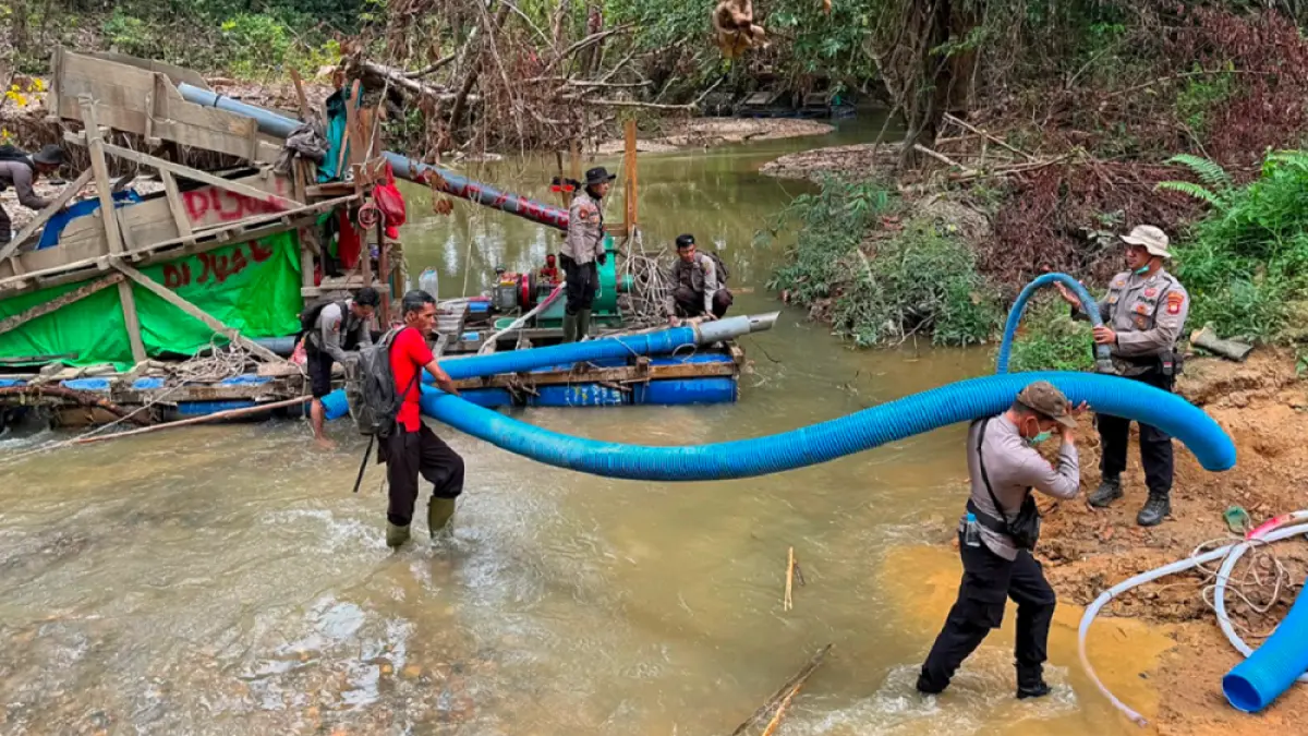 Petugas membongkar peralatan atau mesin dompeng milik penambang emas liar di tepi Sungai Boyan, Senin (27/7). (Humas Polri)