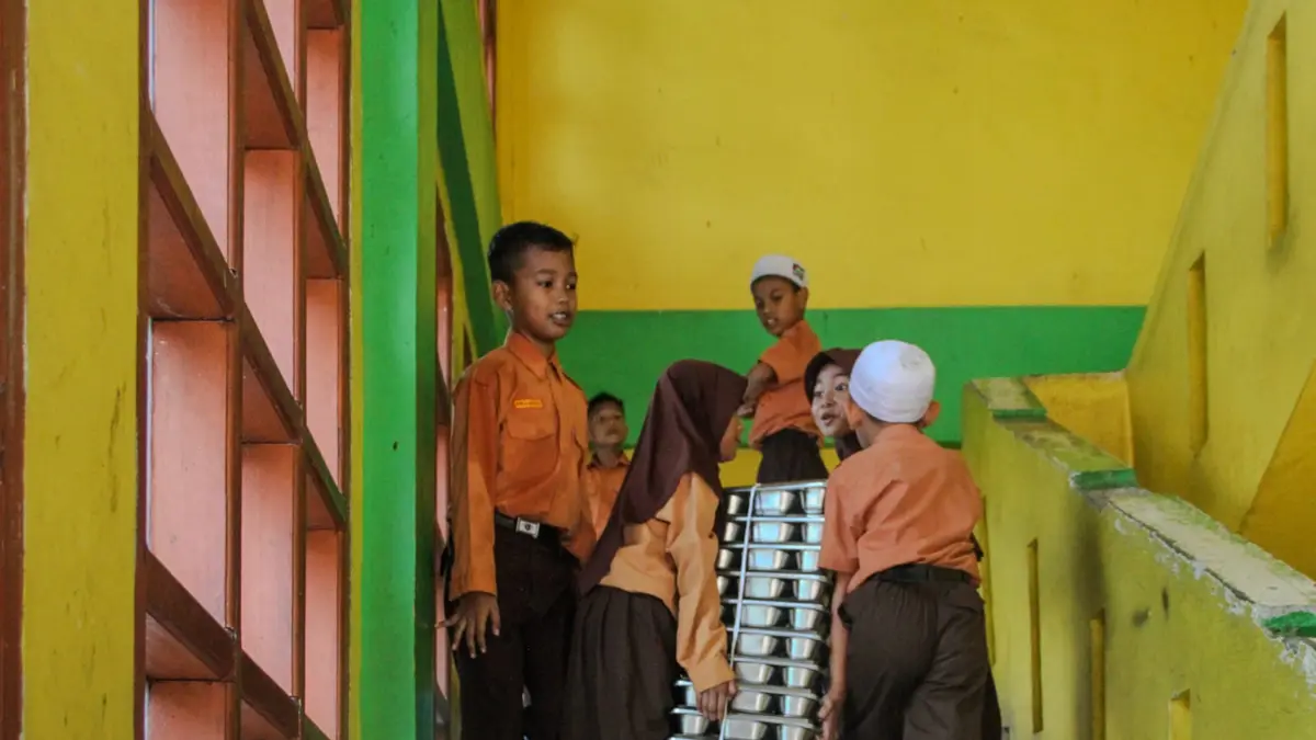 Siswa Sekolah Dasar Negeri 3, Banda Aceh mengangkut omprengan berisi makanan bergizi gratis (MBG), Jumat (31/7). (al amin/rakyat aceh)