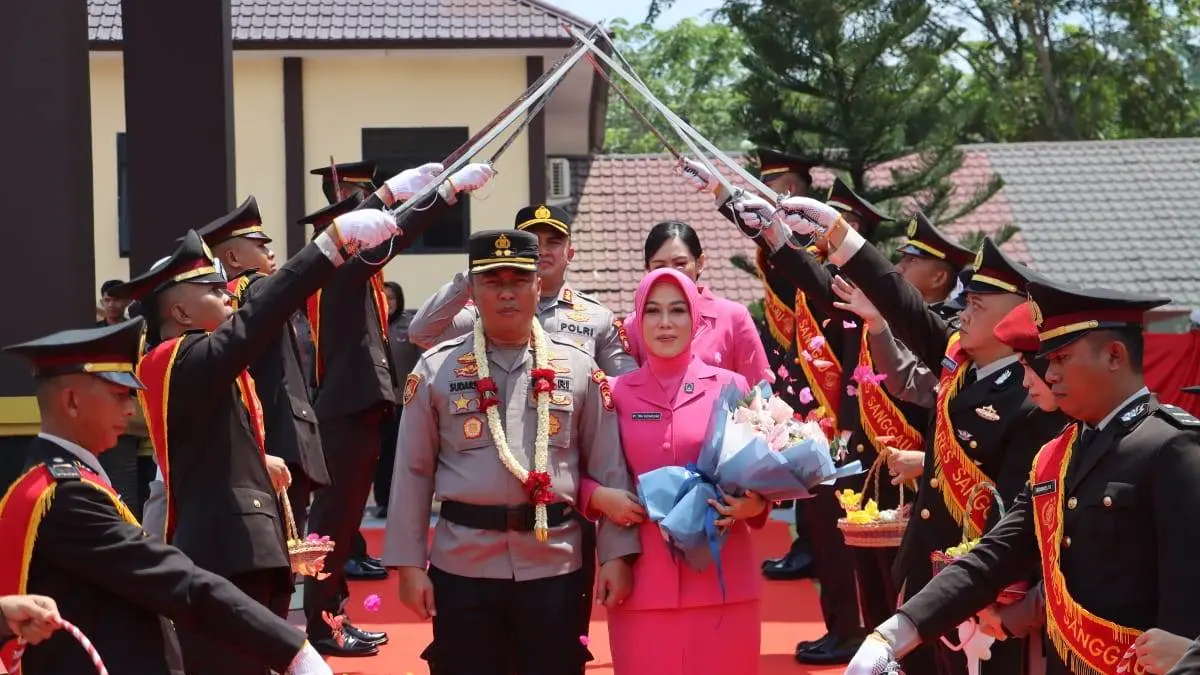 AKBP Sudarsono, S.I.K., M.Si., bersama istri melintasi Gerbang Pedang Pora saat prosesi pelepasan di halaman Mapolres Sanggau, Sabtu (1/8). Tradisi kehormatan tersebut menjadi simbol berakhirnya masa tugasnya sebagai Kapolres Sanggau sekaligus penyerahan estafet kepemimpinan kepada AKBP Kadek Ary Mahardika.