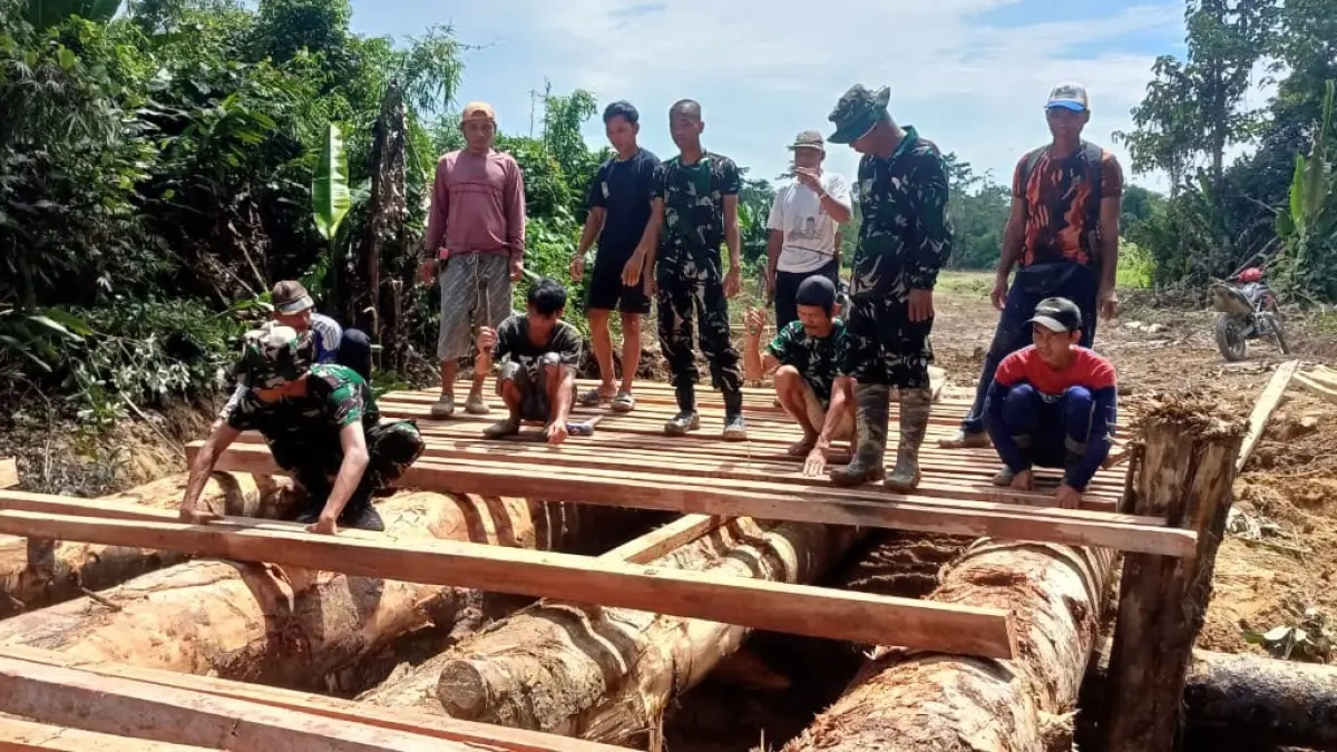 Satgas TNI Manunggal Membangun Desa (TMMD) Reguler Perbatasan (Regtas) ke-129 Kodim 1206/Putussibau saat membangun jembatan.(ISTIMEWA) 