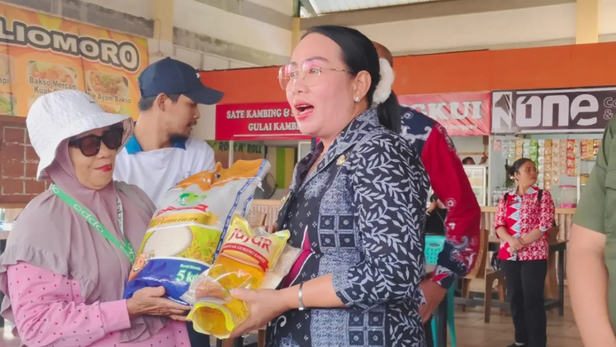 Wakil Bupati Sanggau, Susana Herpena, menyerahkan paket sembako murah kepada warga saat Operasi Pasar Murah di Pasar Seroja, Kecamatan Kapuas, Kamis (6/8). Sebanyak 1000 paket sembako disiapkan Pemprov Kalbar. (AGUNG RAJALI SAPUTRA/PONTIANAK POST)