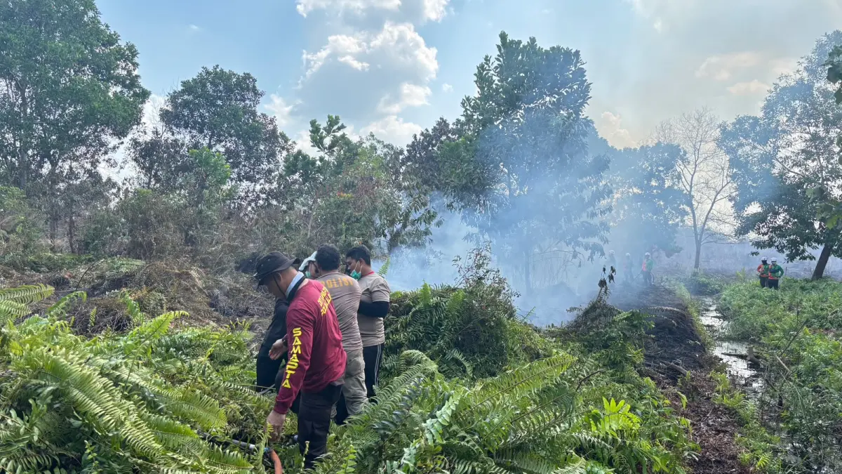 PENDINGINAN: Personel Polres Kubu Raya melakukan pendinginan di lahan gambut bekas terbakar di Jalan Rasau Jaya, Desa Kuala Dua, Kecamatan Sungai Raya, Kamis (6/8). Upaya tersebut dilakukan untuk memadamkan bara yang masih tersimpan di bawah permukaan tanah dan mencegah api kembali menyala di kawasan dekat SMKN 1 Sungai Raya.