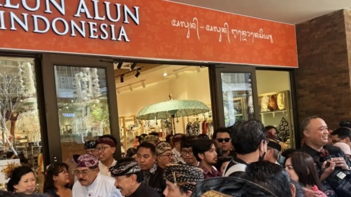 Dokumentasi pengunjung KEK Kura Kura Bali saat melewati gerai dengan aksara Bali di area mal Sira Village Grand Outlet, Denpasar, Jumat (31/7). (ANTARA/Ni Putu Putri Muliantari)