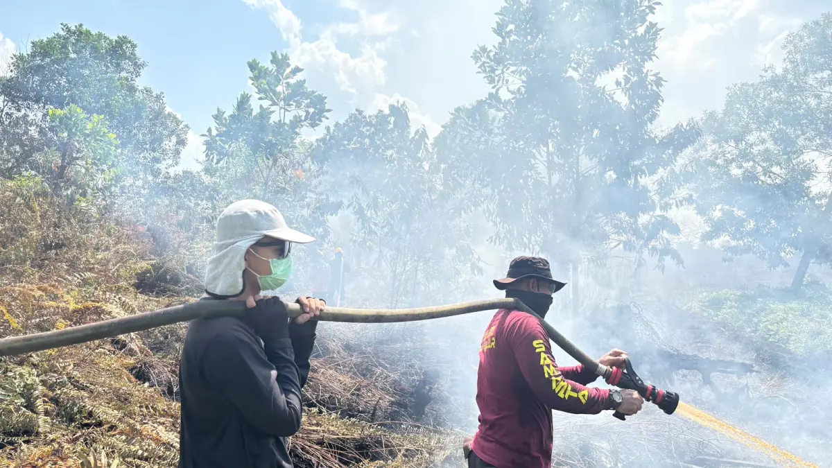 : Personel Polres Kubu Raya melakukan pendinginan di lokasi bekas kebakaran hutan dan lahan (karhutla) di Jalan Rasau Jaya, Desa Kuala Dua, Kecamatan Sungai Raya, Kamis (6/8). (ISTIMEWA)


