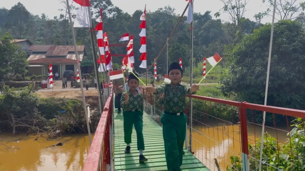 Warga melewati jembatan gantung garuda di Dusun Pemantas, Desa Darit, Kecamatan Menyuke, untuk pertama kali. Jembatan tersebut mempermudah akses warga menuju pusat kecamatan. (KODIM 1210/LANDAK)