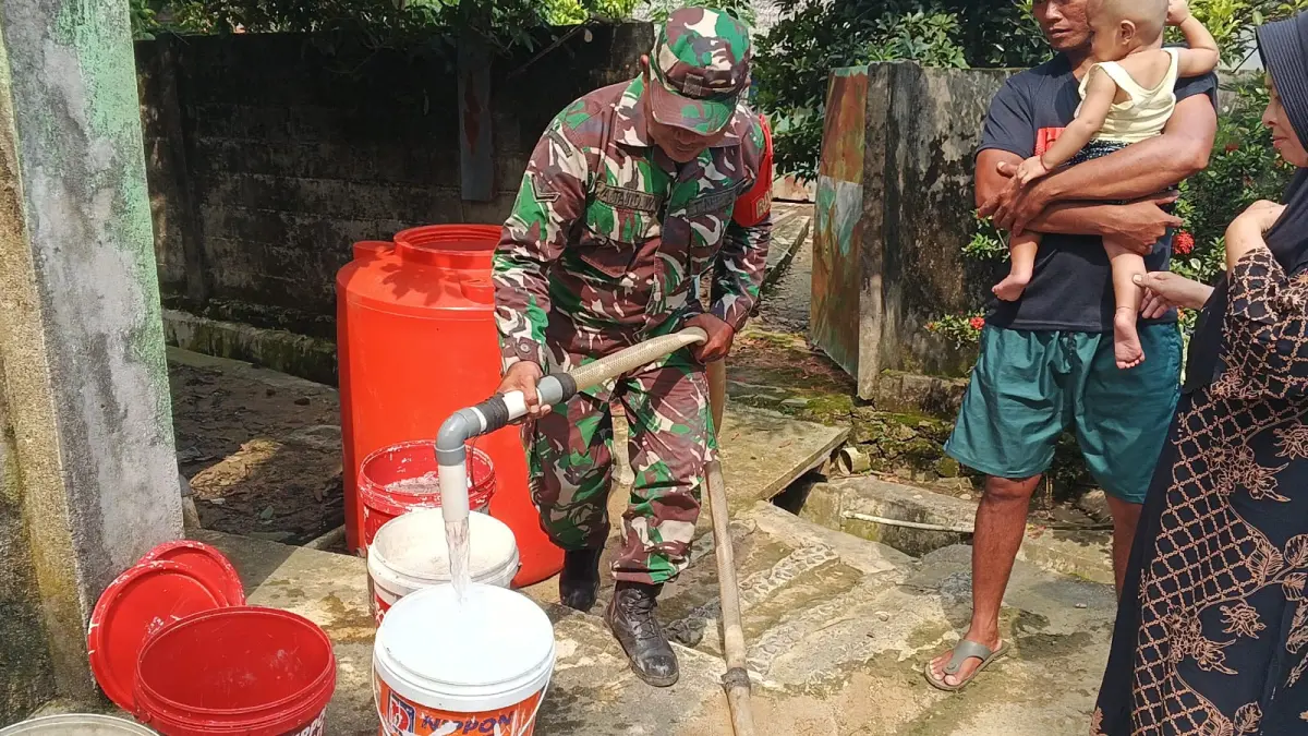 Anggota Koramil Sungai Pinyuh menyalurkan air bersih kepada warga.