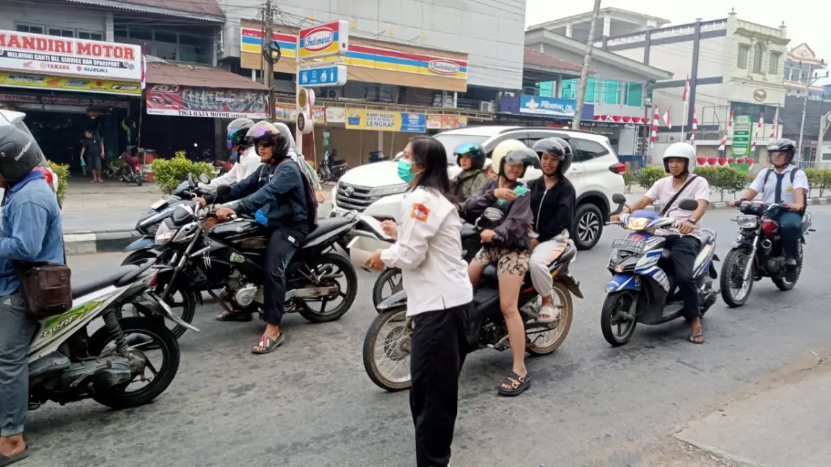 Petugas Dinas Kesehatan Kabupaten Sanggau membagikan masker kepada pengguna jalan di simpang lampu merah Pasar Sentral, Rabu (12/8). (AGUNG RAJALI SAPUTRA/PONTIANAK POST)
