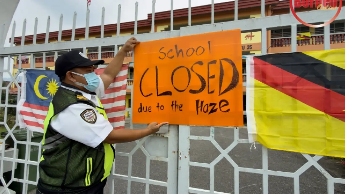 Petugas sebuah sekolah di Serian, Sarawak memasang pengumuman tentang penutupan sementara sekolah akibat kabut asap (jerebu). (Utusan Borneo)