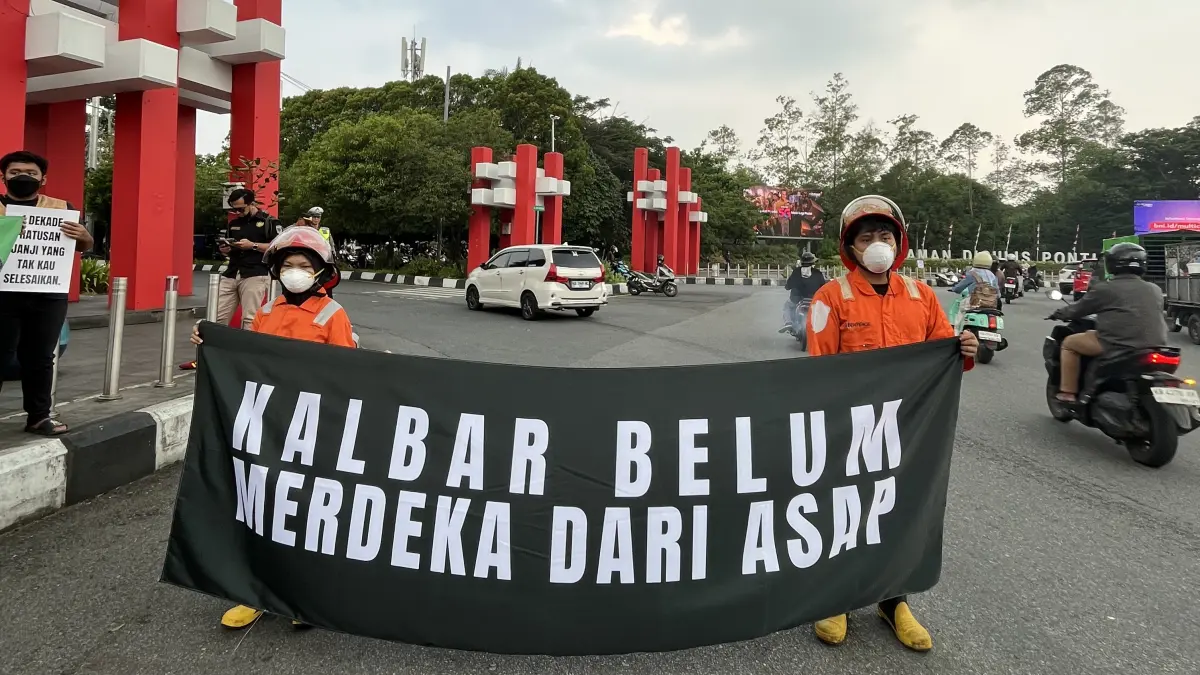 UNJUK RASA: Peserta Aliansi Darurat Asap membentangkan spanduk saat aksi damai menyoroti persoalan karhutla dan kabut asap di kawasan Tugu Digulis Pontianak, Jumat (14/8/2026).&nbsp;