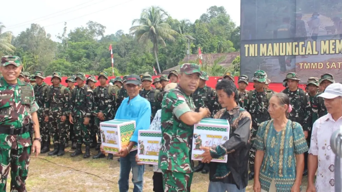 Brigjen TNI Agus Firman Yusmono Irdam XII/Tanjungpura saat menyerhkan tali asih kepada warga di penutupan TMMD.  (ISTIMEWA)