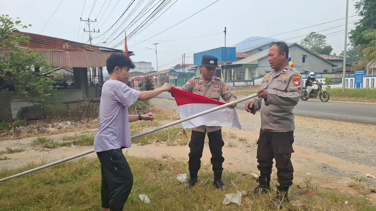 Jajaran Polsek Singkawang Selatan membantu warga memasang bendera Merah Putih, Kamis (13/8/2026). (HUMAS POLRES)