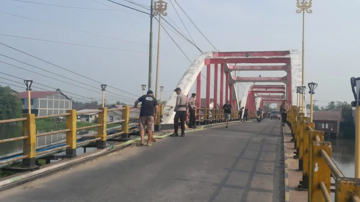 Kegiatan menyemprotkan air ke lobang pembuangan air di jembatan. Kegiatan ini dilaksanakan dalam baksos yang dilakukan BPK Sambas bersama Polres dan Dishub Sambas. (ISTIMEWA)