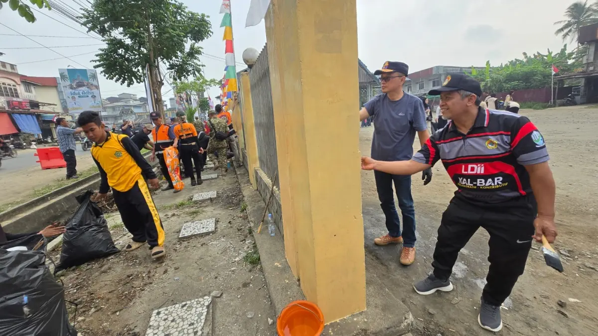 Ketua DPW LDII Kalbar, Susanto dan Kadishub-LH Mempawah, Raja Fajar Azansyah ikut mengecat pagar terminal Sungai Pinyuh. (ISTIMEWA)