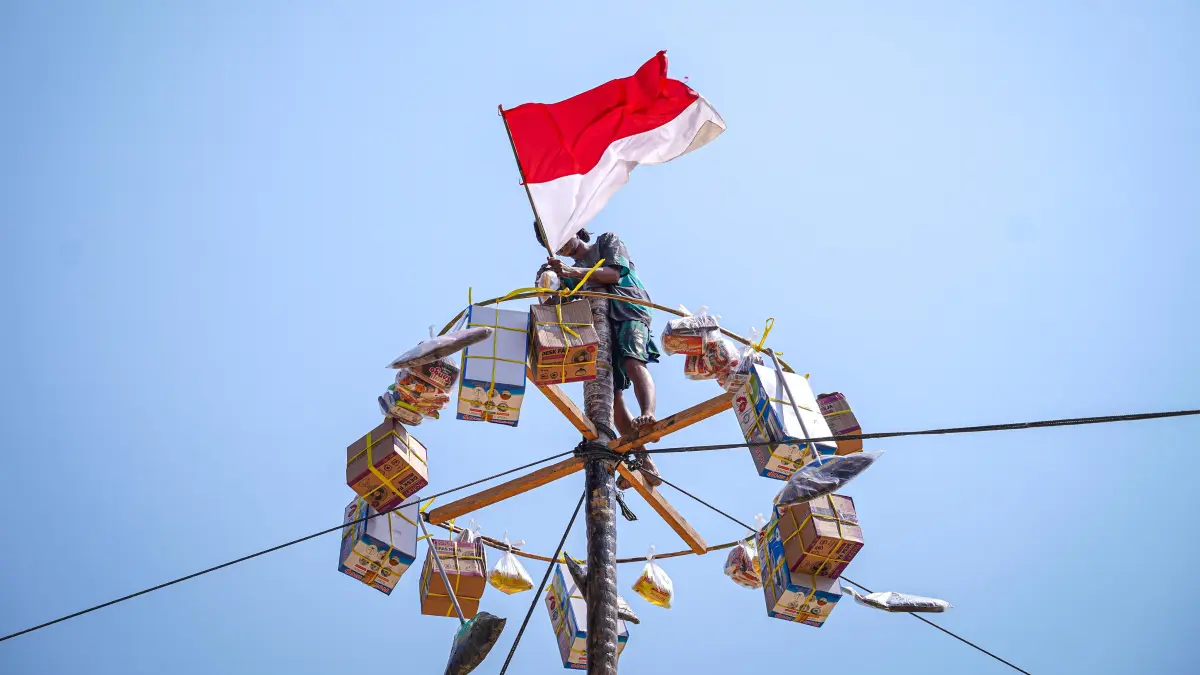 PANJAT PINANG: Warga bergotong royong menaklukkan tantangan panjat pinang sebagai salah satu perlombaan dalam rangkaian perayaan HUT ke-81 RI di Desa Pelapis, Kecamatan Kepulauan Karimata, Kabupaten Kayong Utara. 