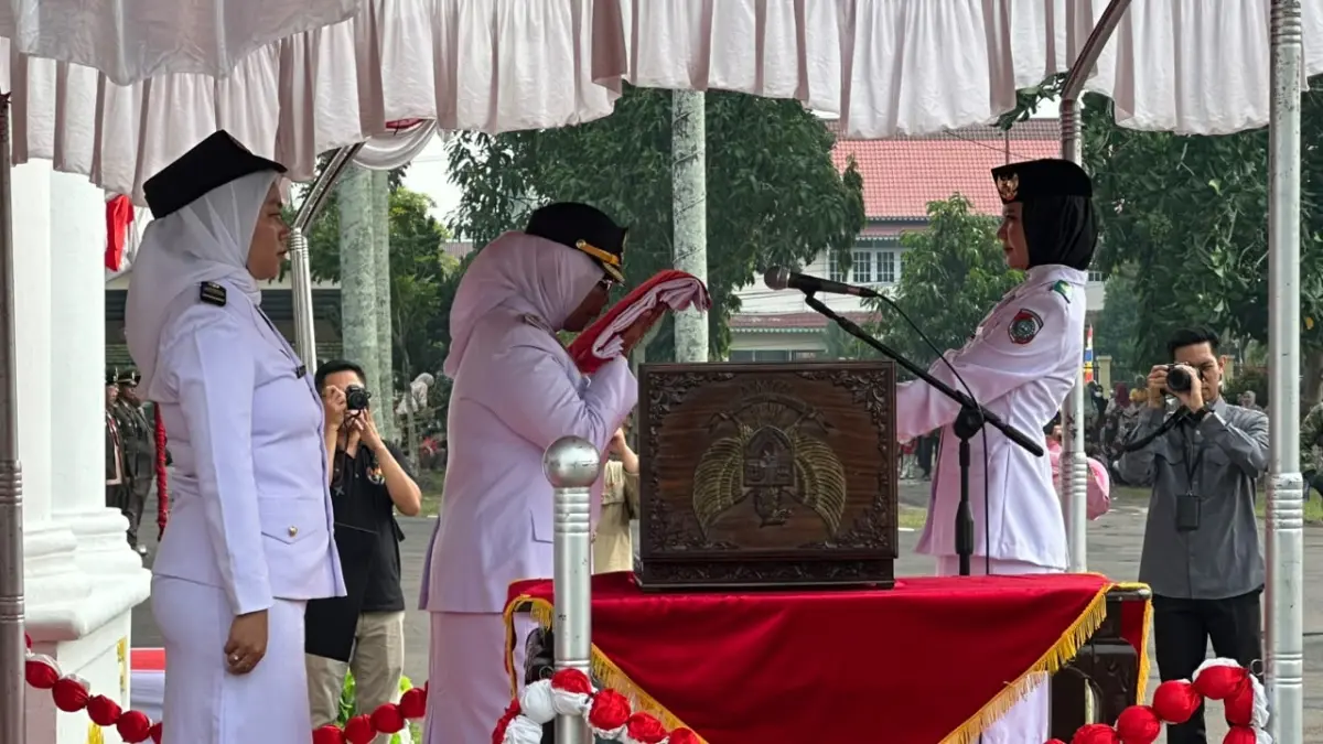 Bupati Mempawah, Erlina menyerahkan bendera merah putih kepada petugas pembawa baki.