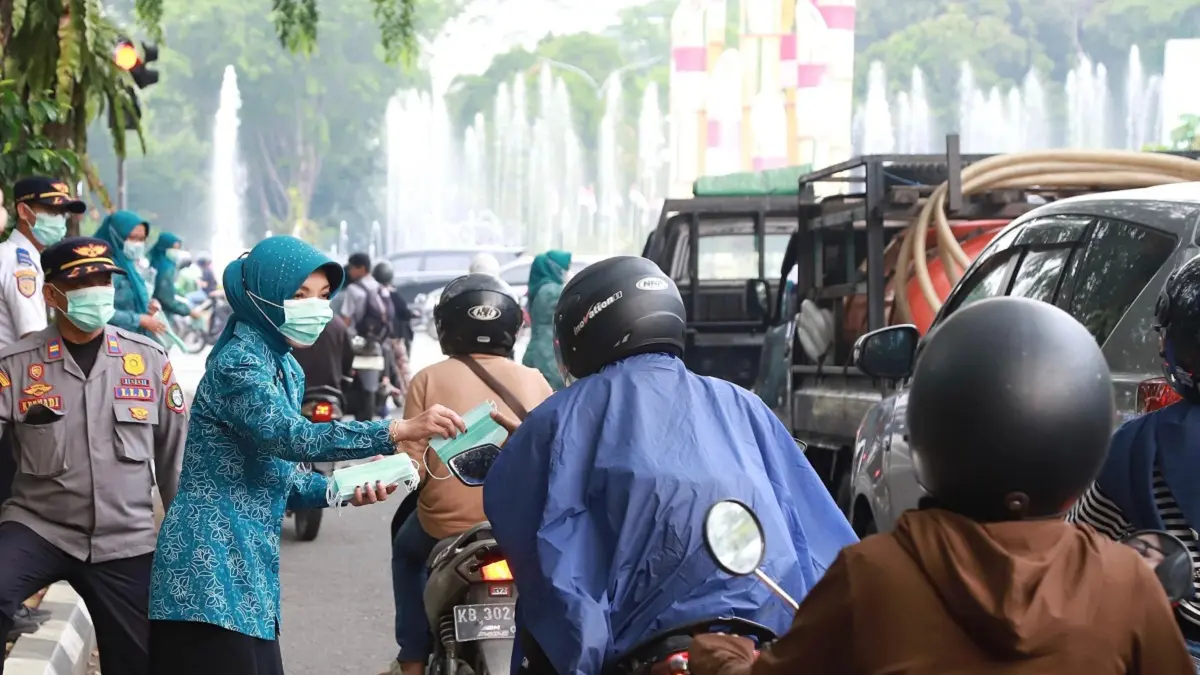 Ketua TP PKK Kota Pontianak Yanieta Arbiastutie bersama kader PKK dan Karang Taruna membagikan masker kepada masyarakat, khususnya pengendara sepeda motor di bundaran Digulis Untan, Rabu (19/8/2026) sore.(Pemkot Pontianak)