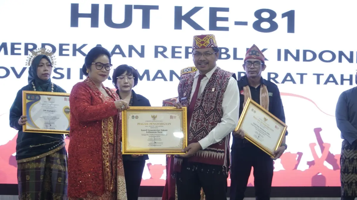 PENGHARGAAN KEKAYAAN INTELEKTUAL: Kepala Kanwil Kemenkum Kalbar Jonny Pesta Simamora menerima penghargaan dari Gubernur Kalbar Ria Norsan.