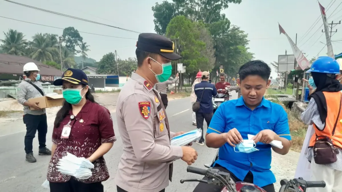 Personel Polsek Mandor bersama Forkopimca, tenaga kesehatan, dan pihak perusahaan membagikan masker kepada masyarakat dan pengguna jalan sebagai upaya melindungi warga dari paparan kabut asap di Kecamatan Mandor, Kabupaten Landak, Kamis (20/8/2026).